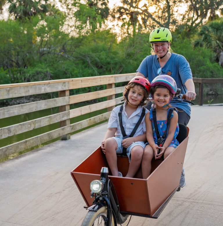 A family riding a cargo bike on a Brownsville trail